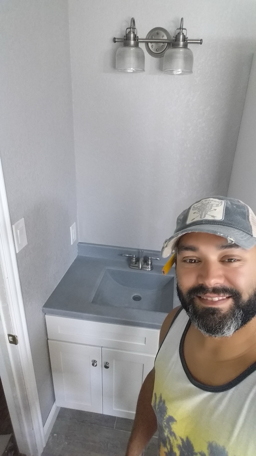 Juan Martinez, owner of MLA Contracting, next to a finished vanity