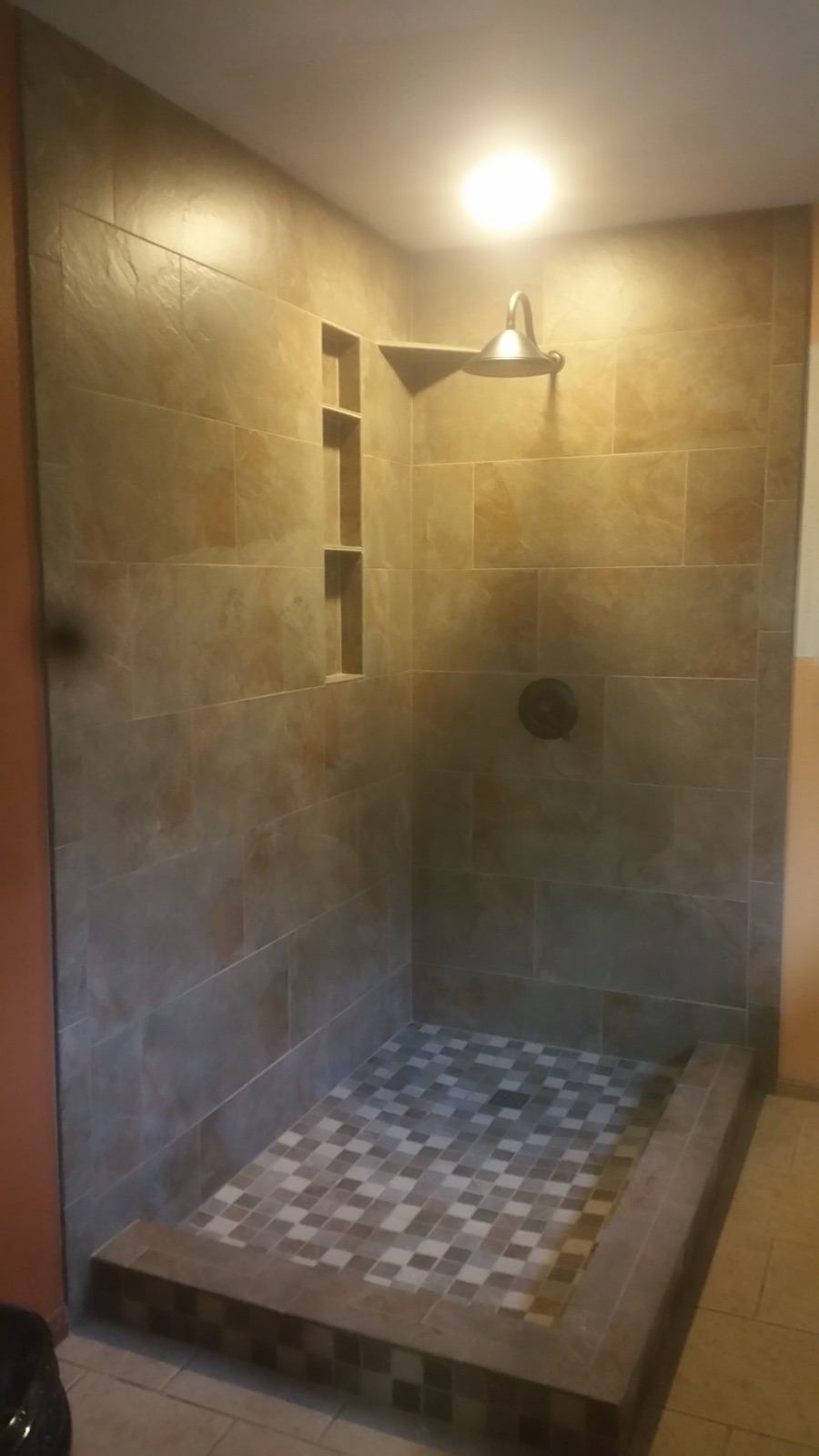 Slate tile walk-in shower with mosaic floor and niche