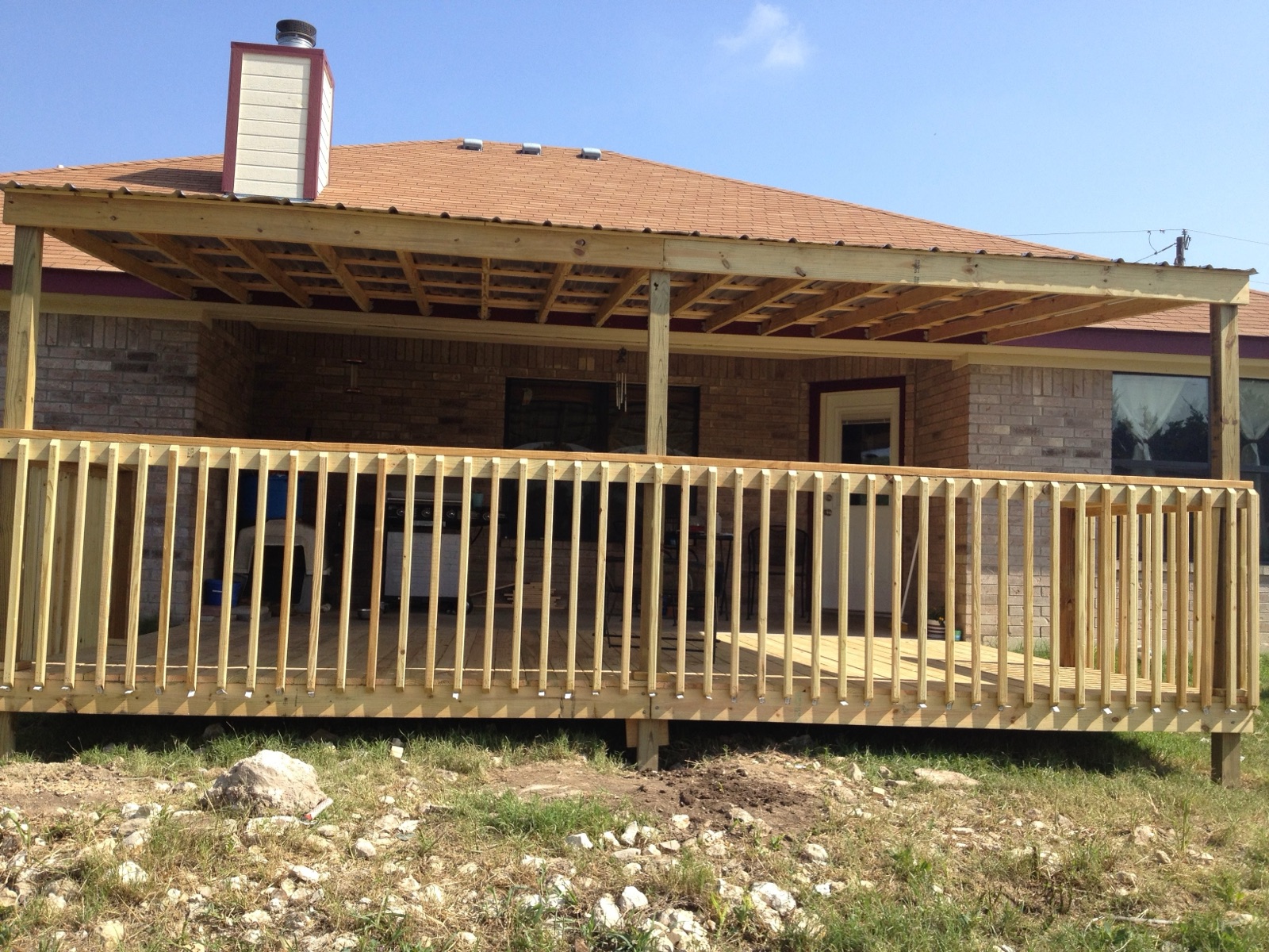 Wood patio cover and deck on a brick home